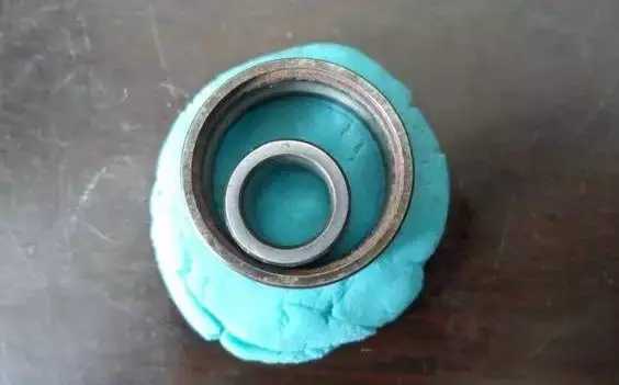 將深溝球軸承的內外圈放到橡膠泥上,輕輕地按進去一點